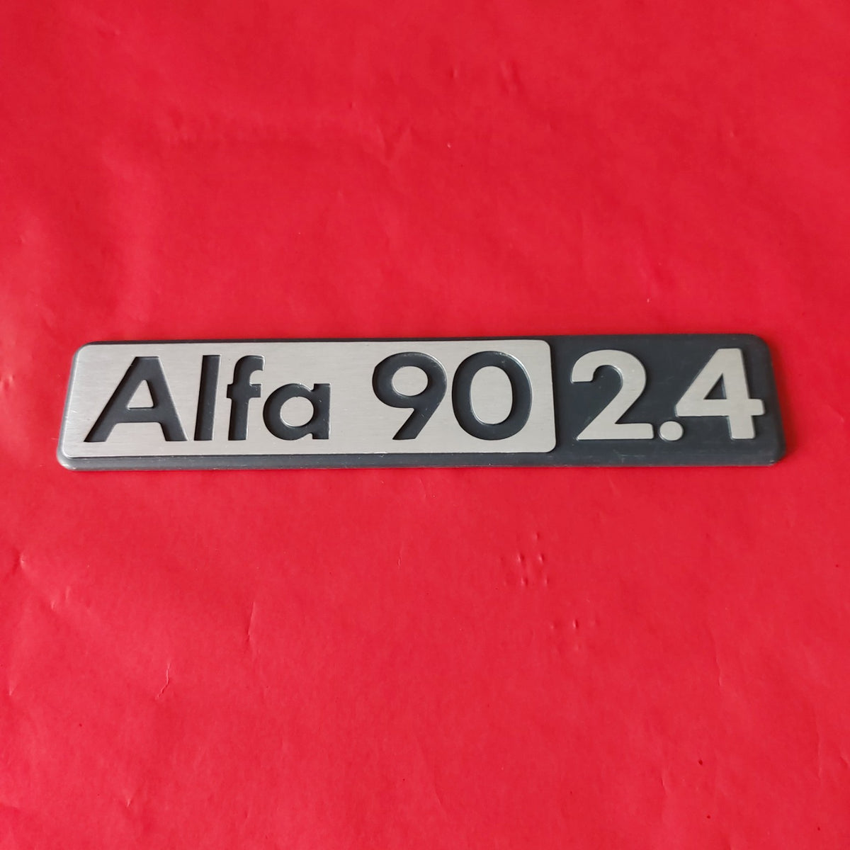 Stemma Alfa 90 2.4 NOS in metallo, vista frontale