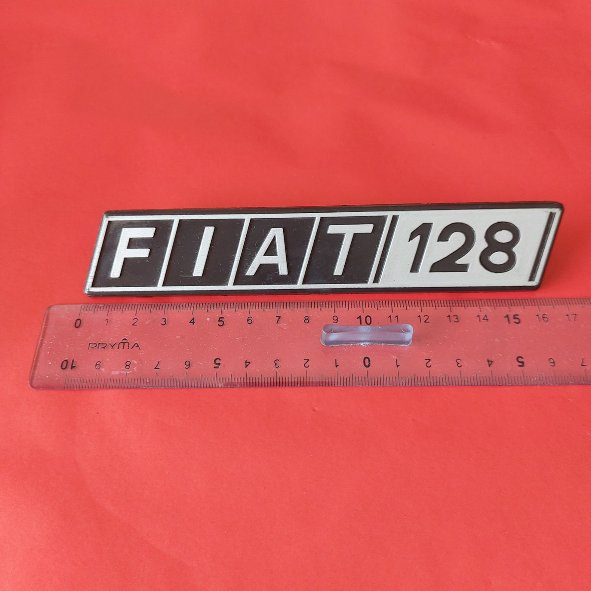 Stemma FIAT 128 NOS con righello per riferimento dimensionale
